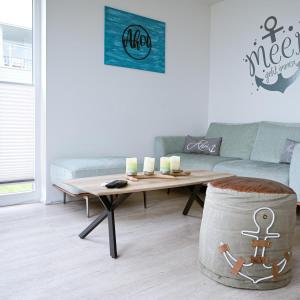 a living room with a coffee table and a couch at Ahoi Lodge in Olpenitz