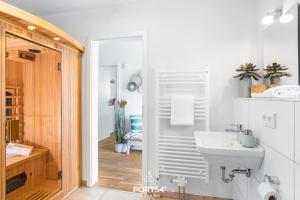 a bathroom with a sink and a mirror at Ahoi Lodge in Olpenitz