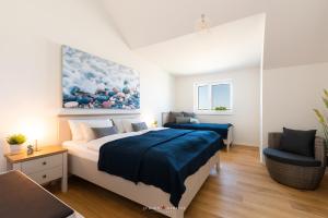 una camera da letto con due letti e una sedia di Hafenwelt a Olpenitz