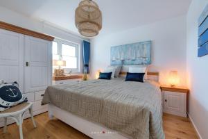 a bedroom with a large bed with blue pillows at Seestern in Olpenitz