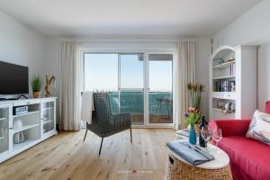 a living room with a red couch and a red chair at Seestern in Olpenitz +18 photos