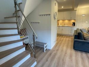 a living room with a staircase and a kitchen at Stuuv twee in Gelting