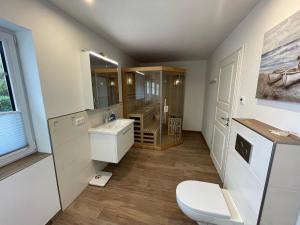 a bathroom with a toilet and a sink and a shower at Stuuv twee in Gelting