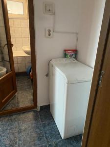 a small kitchen with a white refrigerator in a room at Apartament parter in Craiova