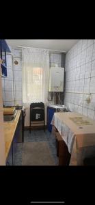 a small kitchen with a table and a sink at Apartament parter in Craiova