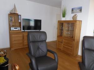 a living room with a chair and a flat screen tv at Apartment Sterntaucher in Olpenitz