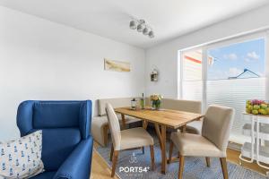 a dining room with a table and a blue chair at Captainslodge in Olpenitz
