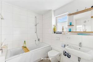 a bathroom with a tub and a sink and a toilet at Captainslodge in Olpenitz