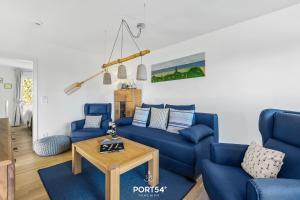 a living room with blue couches and a table at Captainslodge in Olpenitz +23 photos