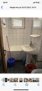 a bathroom with a sink and a toilet and a tub at Apartament parter in Craiova