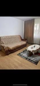 a bedroom with a bed and a coffee table at Apartament parter in Craiova