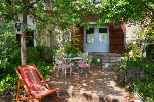 un patio con sillas y una mesa frente a una casa en Ca la Cèlia -Loft, en Maçanet de Cabrenys