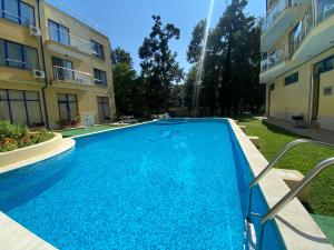 a swimming pool in a yard next to a building at Pop Аrt Bungalows in Primorsko