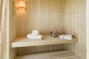 eine Sauna mit Handtüchern auf einem Holzregal in der Unterkunft Meeresmelodie in Olpenitz