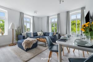 sala de estar con sofá azul y mesa en Ferienwohnung Hofwächter, App 13 Emmelsbüll en Emmelsbüll-Horsbüll