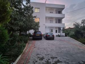 deux voitures garées devant un bâtiment dans l'établissement Modern & Spacious 3 bedroom First Floor Apartment/Villa, à Tirana