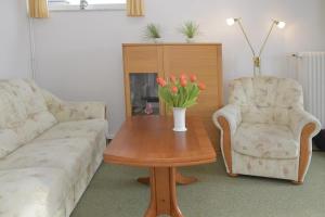 uma sala de estar com uma mesa com um vaso de flores em Nordsee em Büsum