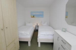 um quarto branco com 2 camas e um lavatório em Nordsee em Büsum