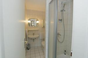 uma casa de banho com um chuveiro, um lavatório e um WC. em Nordsee em Büsum
