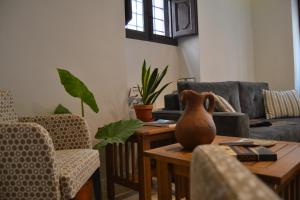 een woonkamer met een bank en een tafel met een vaas erop bij Hotel La Vera Cruz in Caravaca de la Cruz