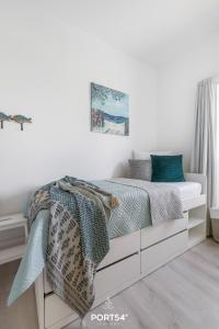 - une chambre blanche dotée d'un lit avec des draps bleus dans l'établissement Ferienwohnung Freiherr, App 8 Emmelsbüll, à Emmelsbüll-Horsbüll