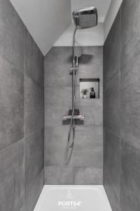 y baño con ducha y azulejos grises. en Momme II en Büsum