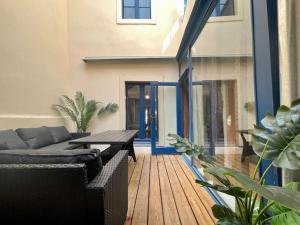 un patio con sofá, mesa y algunas plantas en Le Patio ※ Carnot, en Carcassonne