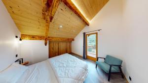 ein Schlafzimmer mit einem Bett, einem Stuhl und einem Fenster in der Unterkunft Chalet Jogidi in Saint-Sorlin-dʼArves