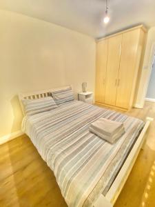 a bedroom with a large bed with striped sheets at Lovely 2 bedroom apartment in Dublin City in Dublin
