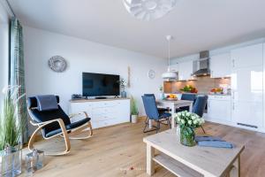 a living room with a table and chairs and a kitchen at Marinablick in Olpenitz