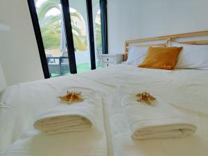 uma cama branca com toalhas com caranguejos em Aldeamento Praia dos Beijinhos em Porches