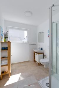 ein Bad mit einem WC, einem Waschbecken und einer Dusche in der Unterkunft Surfer's Bay in Olpenitz