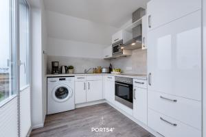 a kitchen with white cabinets and a washer and dryer at Hoppetosse in Olpenitz