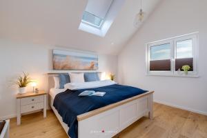 ein Schlafzimmer mit einem Bett und zwei Fenstern in der Unterkunft Sailors View in Olpenitz