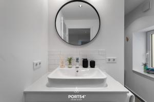 a white bathroom with a sink and a mirror at Leneshus in Flensburg