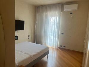 - une chambre avec un lit blanc et une fenêtre dans l'établissement Stella di mare, à Pescara