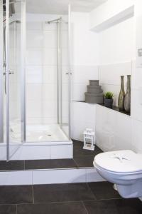 a white bathroom with a shower and a toilet at Biberburg in Flensburg +9 photos