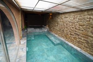 una piscina con una pared de piedra y una piscina en Perafita1750 en Perafita