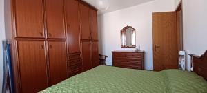 1 dormitorio con cama verde y armarios de madera en Appartamento Velvet Beach, en Senigallia