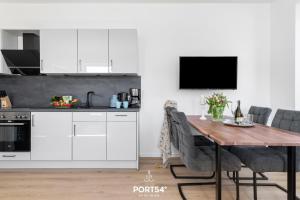 a kitchen with white cabinets and a wooden table at Strandperle Gelting in Gelting