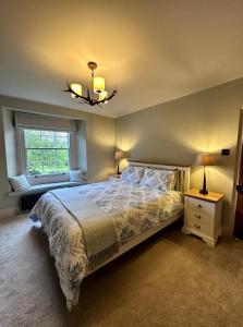 a bedroom with a large bed and a chandelier at Nidd House Farm in Harrogate