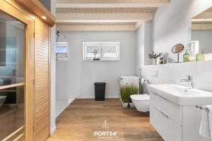 a white bathroom with a sink and a toilet at Ferienhaus Nordseeresort 55 Meerglück Büsum in Büsum