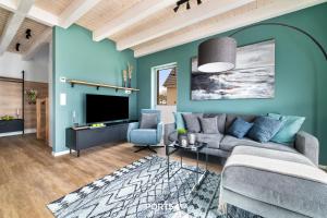 a living room with a couch and a tv at Ferienhaus Nordseeresort 55 Meerglück Büsum in Büsum