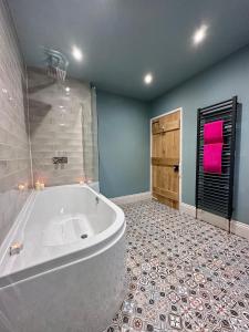 a large bathroom with a tub and a tile floor at Nidd House Farm in Harrogate