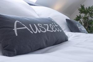 a bed with a black pillow with the word alesis on it at Hakuna Matata in Büsum