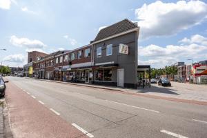 uma rua vazia com um edifício na berma da estrada em Enschede91 em Enschede