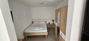 Cette petite chambre comprend un lit avec des draps blancs. dans l'établissement Apartament Damita, à Mangalia