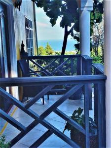 a porch with a bench and a tree on it at BelleAir Views in Gros Islet