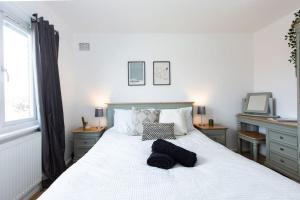 a bedroom with a white bed with two black towels on it at Charming 3-Bed Retreat, Excellent Locaton in Nottingham