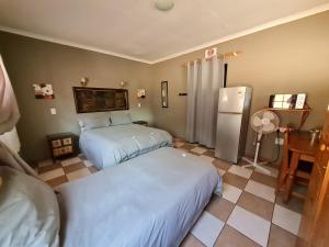 1 dormitorio con 2 camas y nevera en N4 Guest Lodge, en Rustenburg